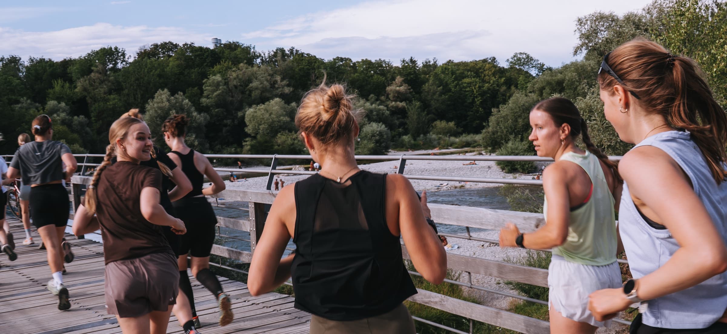Läuferinnen auf einem gemeinsamen Run über eine Holzbrücke